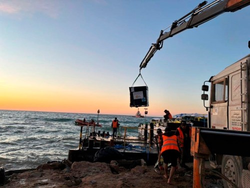 This photo provided by World Central Kitchen shows a crane unloading food packages over a makeshift port on the Gaza Strip, Saturday, March 16, 2024. Spanish NGO Open Arms has sent essential aid to Gaza by a barge towed by a ship from Cyprus. The food was sent by World Central Kitchen, the charity founded by celebrity chef José Andrés, which operates kitchens providing free meals in Gaza. WCK said that it was offloading almost 200 tons of rice, flour and proteins on Saturday and that a second vessel is preparing to set sail from Cyprus with hundreds more tons of food. (World Central Kitchen via AP)