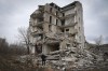 Local resident Yevhen, 34, looks at his home in an apartment house damaged in 2022 heavy battles with the Russian troops in Izium, Kharkiv region, Ukraine, Sunday, March 17, 2024. (AP Photo/Efrem Lukatsky)
