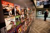 FILE - The Sports Museum curator Richard Johnson, right, stands near an exhibit that displays cover photos from the sports magazine Sports Illustrated in the museum at the TD Garden, in Boston, Dec. 17, 2015. Sports Illustrated will continue operations after the company that owns the brand reached an agreement with a new publisher for its print and digital products, Monday, March 18, 2024. (AP Photo/Steven Senne, File)