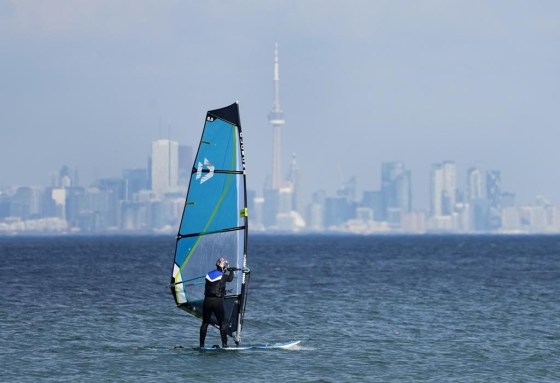 A windsurfer cuts through the waves along Lake Ontario overlooking the Toronto skyline on a warm winter day in February. (Nathan Denette / The Canadian Press files)