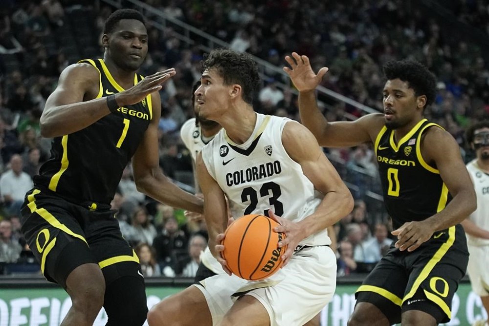 Colorado forward Tristan da Silva (23) drives against Oregon center N'Faly Dante (1) and Oregon guard Kario Oquendo (0) during the second half of an NCAA college basketball game in the championship of the Pac-12 tournament Saturday, March 16, 2024, in Las Vegas. (AP Photo/John Locher)