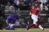 Cincinnati Reds' TJ Friedl reacts to being hit by his foul ball during the third inning of a spring training baseball game on Thursday, March 7, 2024, in Goodyear, Ariz. Also seen are Chicago Cubs catcher Jorge Alfaro and home plate umpire Alan Porter. (AP Photo/Carolyn Kaster)