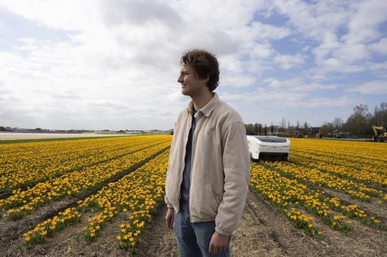 Allan Visser, a third-generation tulip farmer, is seen next to Theo the robot, in Noordwijkerhout, Netherlands. (Peter Dejong / The Associated Press)