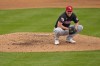 Cleveland Guardians pitcher Shane Bieber smiles after losing control of his pitch in the rain during the second inning of a spring training baseball game against the Oakland Athletics, Thursday, March 7, 2024, in Mesa, Ariz. (AP Photo/Matt York)