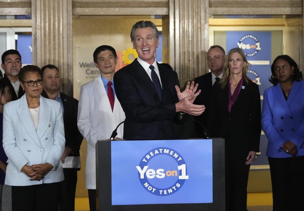 FILE - California Gov. Gavin Newsom speaks in support of Proposition 1, a $6.38 billion bond ballot measure, during a news conference at the Los Angeles General Medical Center in Los Angeles, Wednesday, Jan. 3, 2024. California voters have passed the measure that will impose strict requirements on counties to spend on housing and drug treatment programs to tackle the state’s homelessness crisis. Los Angeles Mayor Karen Bass listens at left. (AP Photo/Damian Dovarganes, File)