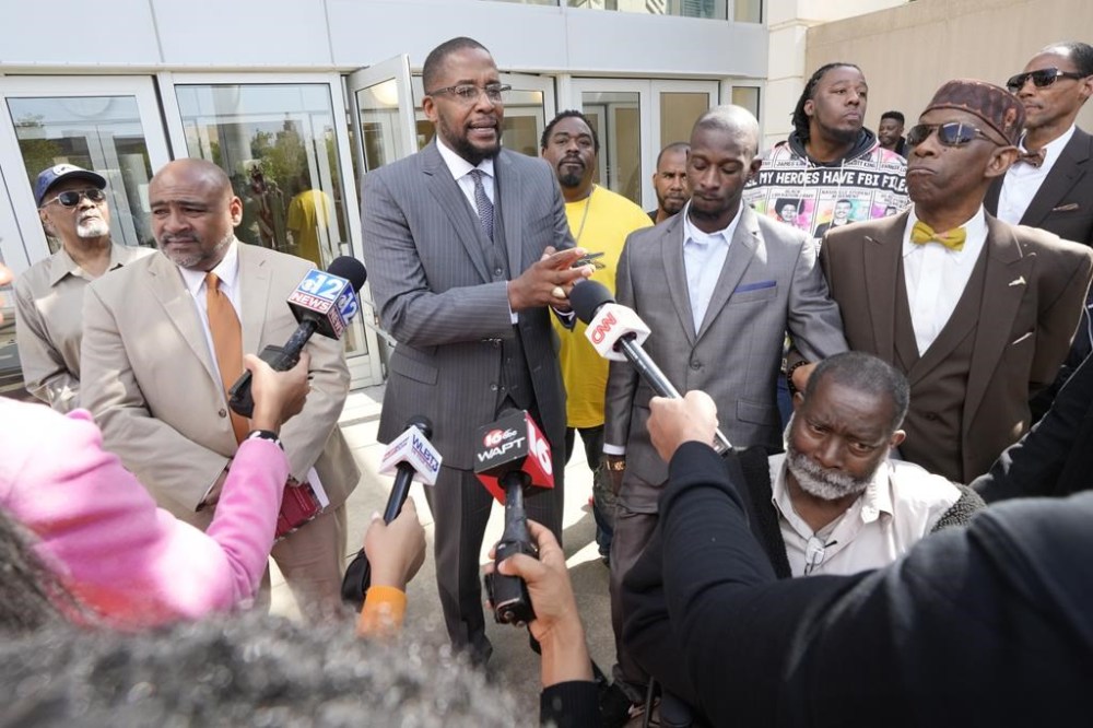 Civil lead counsel Malik Shabazz, center, speaks to reporters following the sentencing of the fourth former Rankin County law enforcement officer, while his client Michael Corey Jenkins, right, listens while outside the federal courthouse in Jackson, Miss., Wednesday, March 20, 2024. Christian Dedmon was sentenced for his part in the racist torture of Parker and Michael Corey Jenkins by a group of white officers who called themselves the “Goon Squad”. AP Photo/Rogelio V. Solis)
