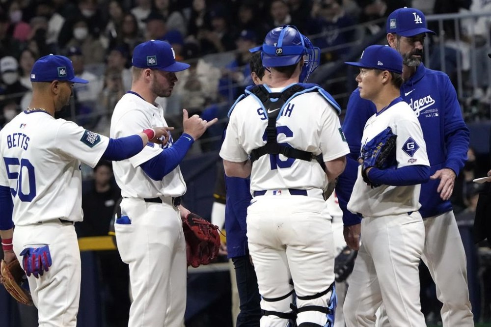 Los Angeles Dodgers starting pitcher Yoshinobu Yamamoto, second from right, speaks to teammates during the first inning of a baseball game against the San Diego Padres at the Gocheok Sky Dome in Seoul, South Korea Thursday, March 21, 2024, in Seoul, South Korea. (AP Photo/Ahn Young-joon)