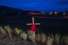 A child's dress is seen on a cross outside a former residential school in Kamloops, B.C., Sunday, June 13, 2021. An interim report from an international group hired to provide advice on identifying and locating the unmarked graves of children who attended residential schools says Canada can should continue funding searches beyond 2025. THE CANADIAN PRESS/Jonathan Hayward