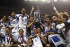 FILE - Greece's coach Otto Rehhagel holds the trophy as he celebrates with his players after beating Portugal, 1-0, in the Euro 2004 soccer championship final match, at the Luz stadium in Lisbon, Portugal, in this July 4, 2004. Greece advancing into a European Championship with a foreign coach is a soccer tradition Gus Poyet aims to build on. It is 20 years since the epic tale of German coach Otto Rehhagel leading an unheralded team to be the surprise champion at Euro 2004. (AP Photo/Frank Augstein, File)