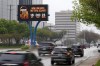 Information regarding the total solar eclipse is shown on a digital bill board as drivers make their way down a busy road in Addison, Texas, Thursday, March 21, 2024. (AP Photo/Tony Gutierrez)