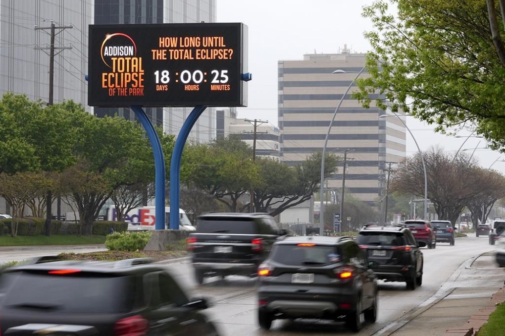 Information regarding the total solar eclipse is shown on a digital bill board as drivers make their way down a busy road in Addison, Texas, Thursday, March 21, 2024. (AP Photo/Tony Gutierrez)