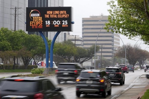 Information regarding the total solar eclipse is shown on a digital bill board as drivers make their way down a busy road in Addison, Texas, Thursday, March 21, 2024. (AP Photo/Tony Gutierrez)