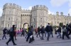 People walk past Windsor Castle in Windsor, England, Saturday, March 23, 2024. Britain's Kate, Princess of Wales's revelation she is undergoing treatment for cancer has sparked an outpouring of support and well wishes from around the world. (AP Photo/Alberto Pezzali)