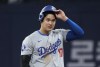 Los Angeles Dodgers designated hitter Shohei Ohtani takes his helmet off after making it to first on a fielder's choice during the fifth inning of an opening day baseball game against the San Diego Padres at the Gocheok Sky Dome in Seoul, South Korea Wednesday, March 20, 2024, in Seoul, South Korea. (AP Photo/Ahn Young-joon)