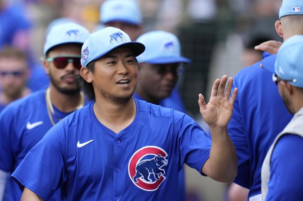 Chicago Cubs starting pitcher Shota Imanaga, of Japan, smiles as he gets high-fives from teammates in the dugout after being replaced during the fifth inning of a spring training baseball game against the Oakland Athletics, Thursday, March 14, 2024, in Mesa, Ariz. (AP Photo/Ross D. Franklin)