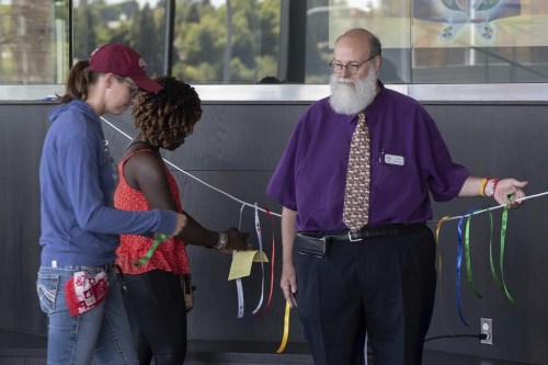 In this image provided by WSU College of Veterinary Medicine, Scott Campbell, right, Veterinary Chaplain at Washington State University's College of Veterinary Medicine, looks on as people tie ribbons honoring pets that have passed away during the Garland Ceremony, that was part of a 