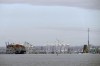 A container ship rests against wreckage of the Francis Scott Key Bridge on Tuesday, March 26, 2024, as seen from Pasadena, Md. The ship rammed into the major bridge in Baltimore early Tuesday, causing it to collapse in a matter of seconds and creating a terrifying scene as several vehicles plunged into the chilly river below. (AP Photo/Mark Schiefelbein)