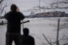 People view container ship as it rests against wreckage of the Francis Scott Key Bridge on Tuesday, March 26, 2024, as seen from Dundalk, Md. The ship rammed into the major bridge in Baltimore early Tuesday, causing it to collapse in a matter of seconds and creating a terrifying scene as several vehicles plunged into the chilly river below. (AP Photo/Matt Rourke)