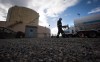 A FortisBC employee walks past a storage tank and delivery trucks at the existing FortisBC Tilbury LNG facility before the groundbreaking for an expansion project in Delta, B.C., on Tuesday, Oct. 21, 2014. An environmental group is suing British Columbia natural gas utility FortisBC, accusing it of 