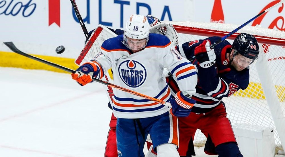 Winnipeg Jets' Josh Morrissey (44) defends as Edmonton Oilers' Zach Hyman (18) tries to tip the puck during first period NHL action in Winnipeg on Tuesday, March 26, 2024. THE CANADIAN PRESS/John Woods