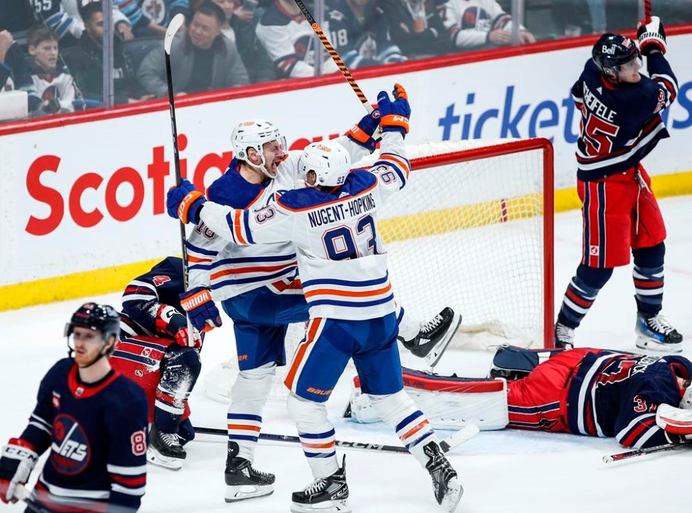 Edmonton Oilers' Zach Hyman (18) and Ryan Nugent-Hopkins (93) celebrate Hyman's game-winning goal against the Winnipeg Jets in NHL overtime action in Winnipeg on Tuesday, March 26, 2024. THE CANADIAN PRESS/John Woods