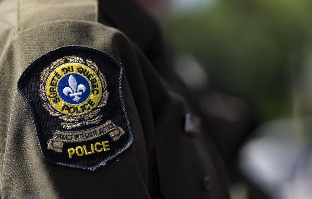 Three men are dead after an apparent avalanche on Quebec's Mount Médaille during their snowmobiling expedition on the Gaspe Peninsula on Tuesday. A Surete du Quebec emblem is seen on an officer’s uniform in Montreal on Aug. 22, 2023. THE CANADIAN PRESS/Christinne Muschi