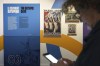 A man checks his phone during an exhibition press day, Wednesday, March 27, 2024 in Paris. Ahead of this summer's Paris Olympics, an exhibit in the French capital shows how the Games have been a 
