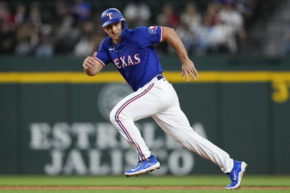 Texas Rangers' Wyatt Langford runs from second to third base on Jared Walsh's RBI single during the second inning of a spring training baseball game against the Boston Red Sox, Monday, March 25, 2024, in Arlington, Texas. (AP Photo/Sam Hodde)