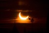 An annular solar eclipse rises over construction cranes and the Peace Tower on Parliament Hill in Ottawa on Thursday, June 10, 2021. THE CANADIAN PRESS/Sean Kilpatrick