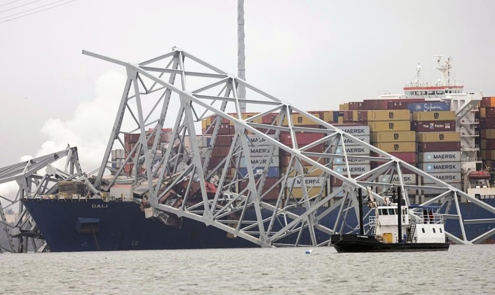 A cargo ship is stuck under the part of the structure of the Francis Scott Key Bridge after the ship hit the bridge Wednesday, March 27, 2024, in Baltimore, Md. (AP Photo/Steve Helber)