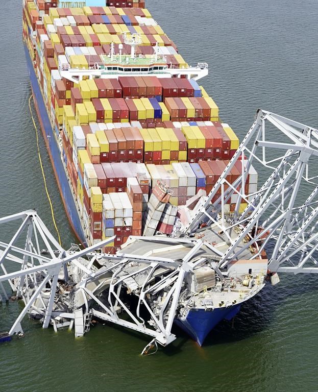 In this aerial image released by the Maryland National Guard, the cargo ship Dali is stuck under part of the structure of the Francis Scott Key Bridge after the ship hit the bridge, Tuesday, March 26, 2024, in Baltimore. (Maryland National Guard via AP)