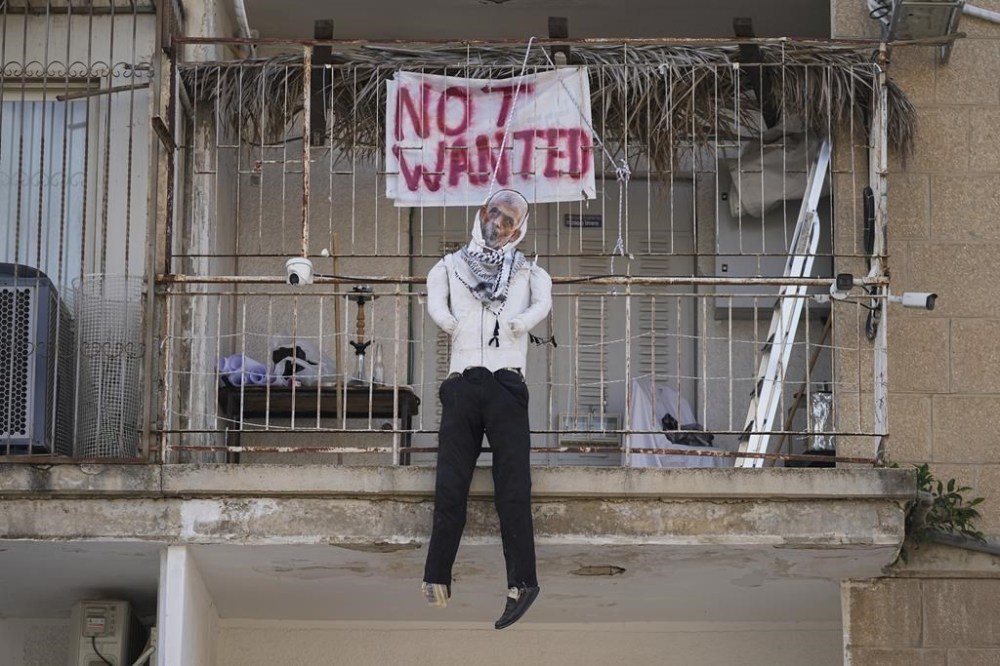 An effigy of Hamas leader Yehya Sinwar hangs off the balcony of an apartment under the sign