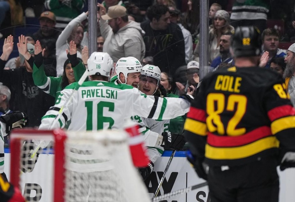 Dallas Stars' Roope Hintz (24), Jamie Benn (14) and Joe Pavelski (16) celebrate Hintz's goal as Vancouver Canucks' Ian Cole (82) watches during the first period of an NHL hockey game in Vancouver, on Thursday, March 28, 2024. THE CANADIAN PRESS/Darryl Dyck