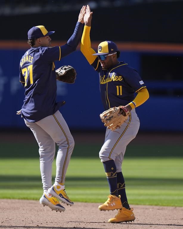 Milwaukee Brewers' Willy Adames, left, celebrates with Jackson Chourio, right, after a baseball game against the New York Mets Friday, March 29, 2024, in New York. The Brewers won 3-1. (AP Photo/Frank Franklin II)