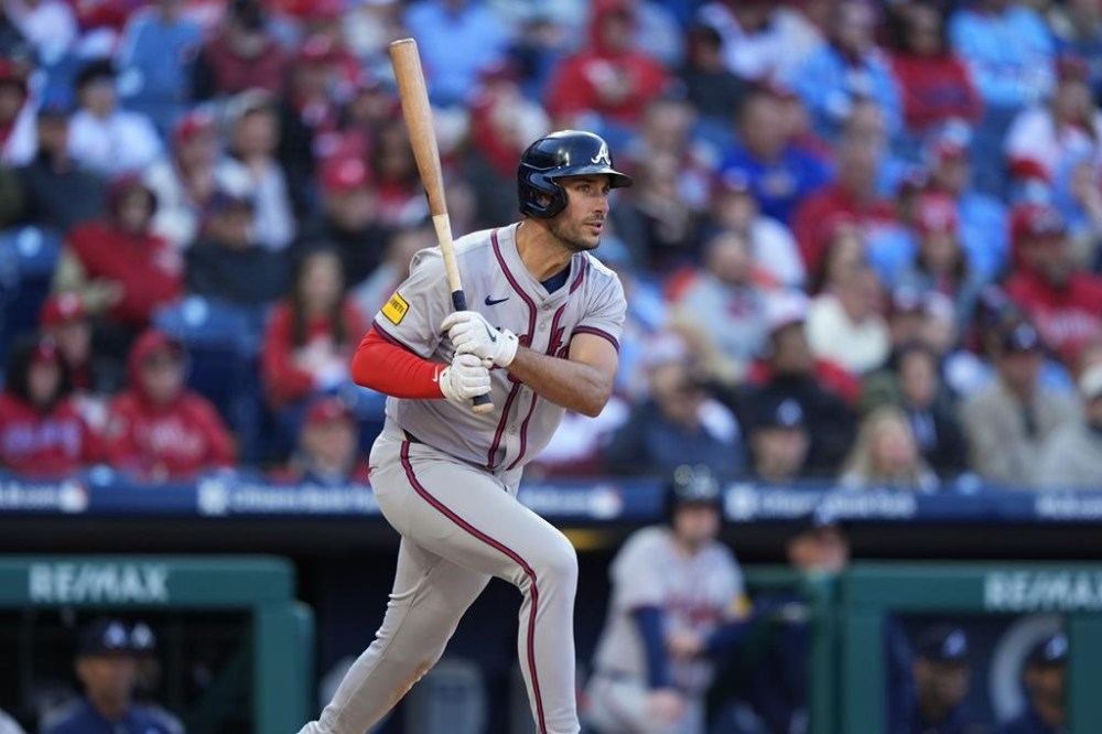 Atlanta Braves' Matt Olson follows through after hitting a three-run double off Philadelphia Phillies pitcher Connor Brogdon during the eighth inning of an opening-day baseball game, Friday, March 29, 2024, in Philadelphia. (AP Photo/Matt Slocum)