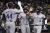 Colorado Rockies shortstop Ezequiel Tovar (14) celebrates with third baseman Elehuris Montero (44) and catcher Elias Diaz after hitting a two-run home run against the Arizona Diamondbacks in the second inning during a baseball game, Saturday, March 30, 2024, in Phoenix. (AP Photo/Rick Scuteri)