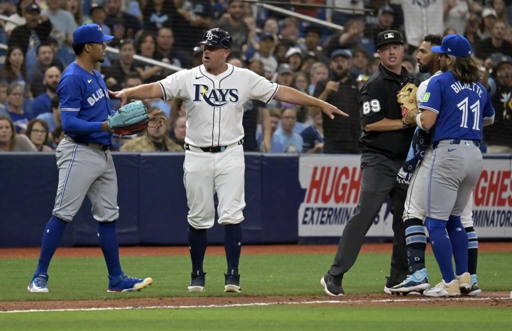 Tampa Bay Rays third base coach Brady Williams, center left, umpire Corey Blaser(89) and Toronto Blue Jays shortstop Bo Bichette (11) try to break up a confrontation between Tampa Bay's Jose Caballero, second right, and Toronto Blue Jays reliever Genesis Cabrera, left, during a baseball game Saturday, March 30, 2024, in St. Petersburg, Fla. Cabrera has received a three-game suspension and a fine for his role in a bench-clearing incident in a 5-1 loss to Tampa Bay. THE CANADIAN PRESS/AP-Steve Nesius