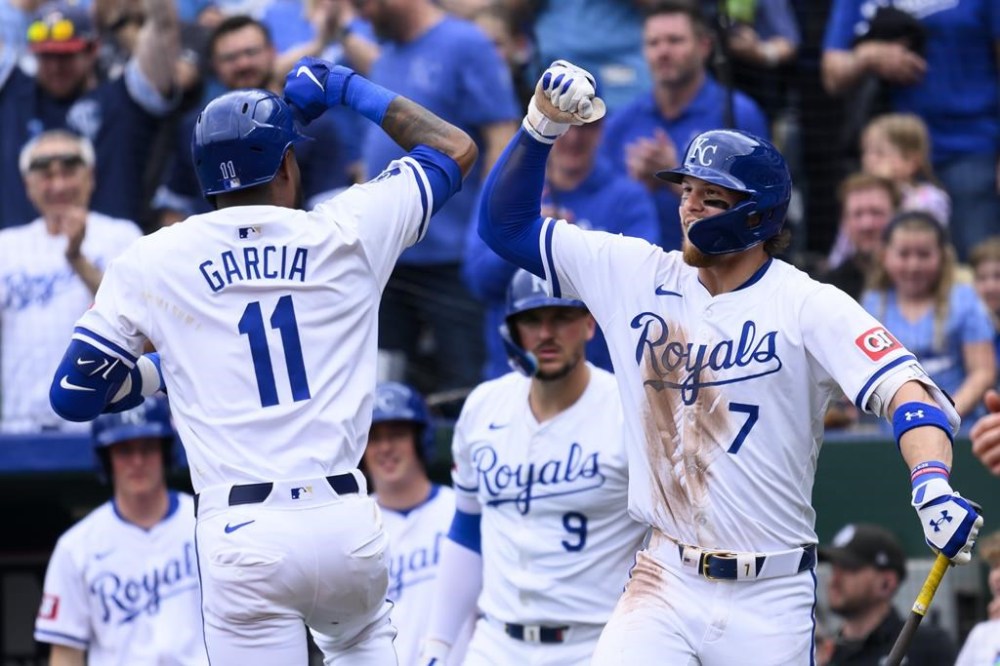 Kansas City Royals' Royals' Bobby Witt Jr. (7) celebrates a home run by Maikel Garcia during the second inning of the team's baseball game against the Minnesota Twins, Sunday, March 31, 2024, in Kansas City, Mo. (AP Photo/Reed Hoffmann)