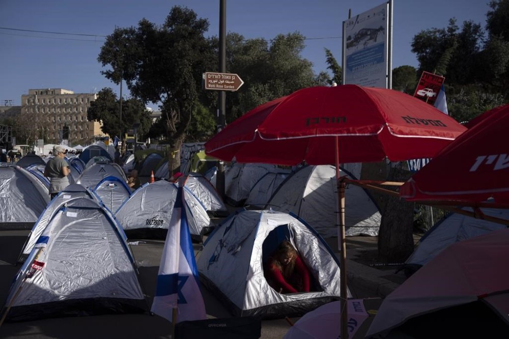 People who protest against Israeli Prime Minister Benjamin Netanyahu's government and call for the release of hostages held in the Gaza Strip by the Hamas, set up a camp near the Knesset, Israel's parliament in Jerusalem, Monday, April 1, 2024. (AP Photo/Leo Correa)