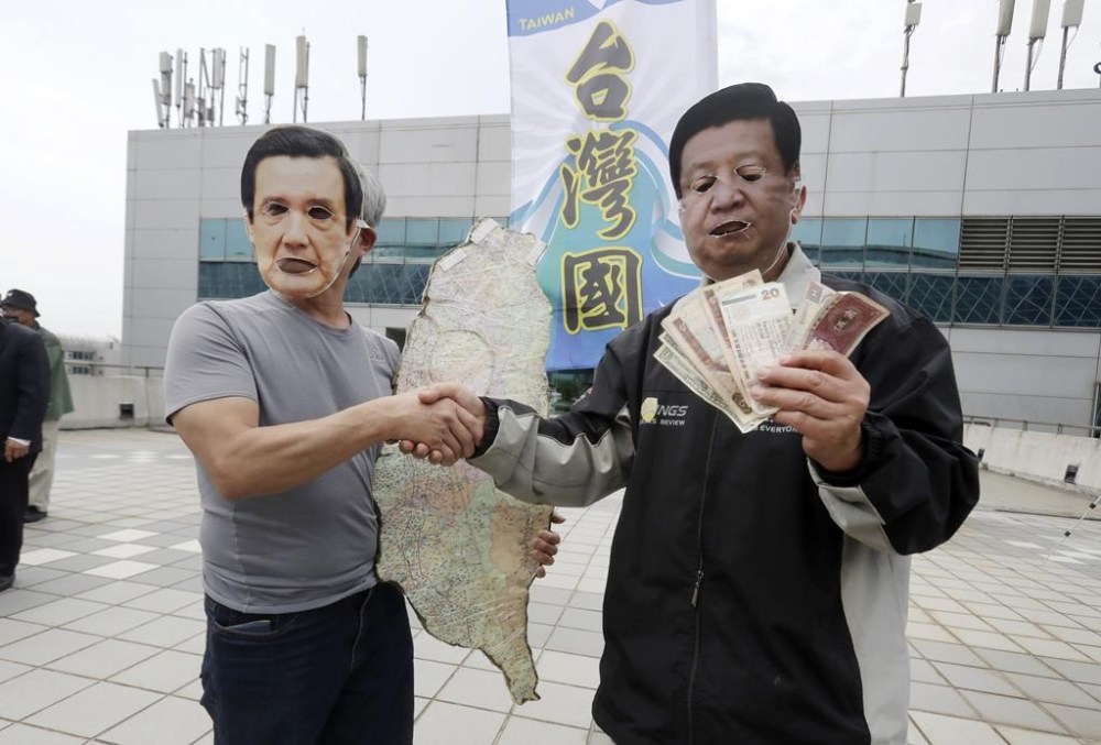Protesters wearing masks of former Taiwanese President Ma Ying-jeou, left, and Chinese President Xi Jinping, right, perform, as Ma leaves for China outside of Taoyuan International Airport in Taoyuan City, Northern Taiwan, Monday, April 1, 2024. (AP Photo/Chiang Ying-ying)