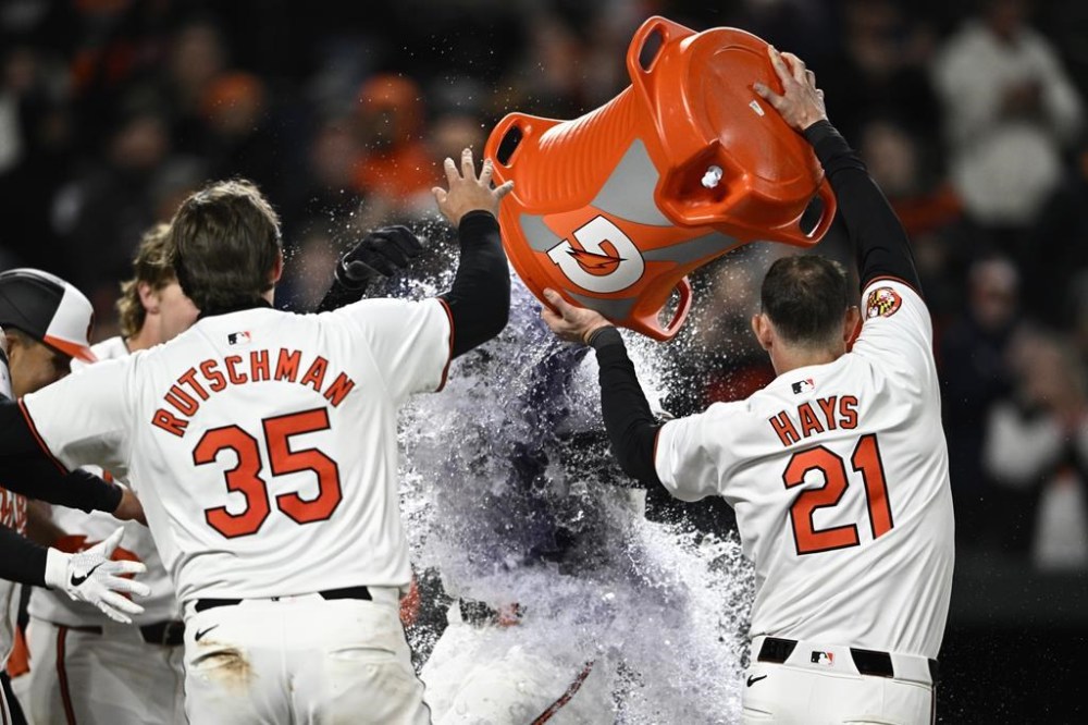 Baltimore Orioles' Jordan Westburg, center obscured, celebrates his two-run walk-off home run with Austin Hays (21), Adley Rutschman (35) and others during the ninth inning of a baseball game against the Kansas City Royals, Monday, April 1, 2024, in Baltimore. (AP Photo/Nick Wass)