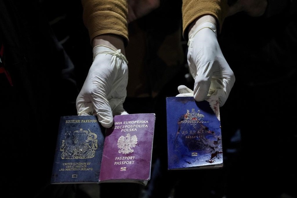 A man displays blood-stained British, Polish, and Australian passports after an Israeli airstrike, in Deir al-Balah, Gaza Strip, Monday, April 1, 2024. Gaza medical officials say an apparent Israeli airstrike killed four international aid workers with the World Central Kitchen charity and their Palestinian driver after they helped deliver food and other supplies to northern Gaza that had arrived hours early by ship. (AP Photo/Abdel Kareem Hana)