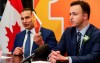 Manitoba Premier Wab Kinew, left, holds up his government's budget as he and Finance Minister Adrien Sala speak to media before the document is read at the Manitoba legislature in Winnipeg, Tuesday, April 2, 2024. THE CANADIAN PRESS/John Woods