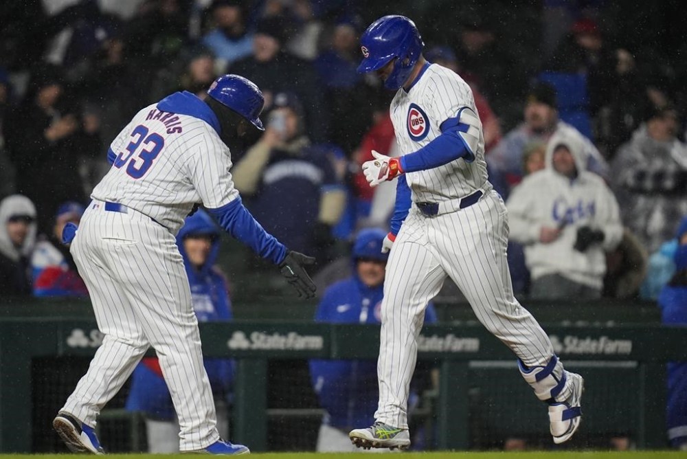 Chicago Cubs' Seiya Suzuki, right, slaps hands with third base coach Willie Harris as runs the bases after hitting a home run against the Colorado Rockies during the fifth inning of a baseball game Wednesday, April 3, 2024, in Chicago. (AP Photo/Erin Hooley)