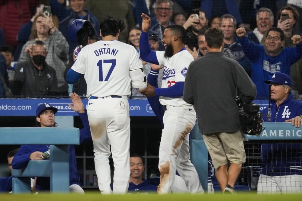 Los Angeles Dodgers designated hitter Shohei Ohtani celebrates with Teoscar Hernandez (37) after hitting a home run during the seventh inning of a baseball game against the San Francisco Giants in Los Angeles, Wednesday, April 3, 2024. (AP Photo/Ashley Landis)