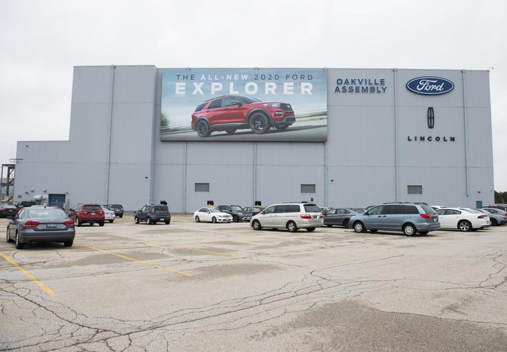 A parking lot with employees' vehicles is shown at the Ford assembly plant in Oakville, Ont., on Thursday, March 19, 2020. Ford Motor Co. is delaying the start of electric vehicle production at its plant in Oakville, Ont., to 2027.THE CANADIAN PRESS/Nathan Denette