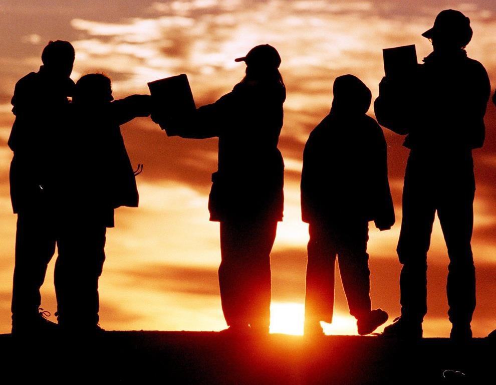 Early risers catch a glimpse of a solar eclipse on the rocks at Peggy's Cove, N.S. on Wednesday Aug. 11, 1999 using an improvised pinhole camera to safely view the phenomenon. If you haven’t been able to secure a pair of solar eclipse sunglasses ahead of the much-anticipated celestial event, do not fret. THE CANADIAN PRESS/Andrew Vaughan