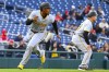Pittsburgh Pirates' Ke'Bryan Hayes, left, heads home past Pirates third base coach Mike Rabelo on a Pirates' Rowdy Tellez's two-run RBI single during the first inning of a baseball game against the Washington Nationals at Nationals Park, Thursday, April 4, 2024, in Washington. (AP Photo/John McDonnell)