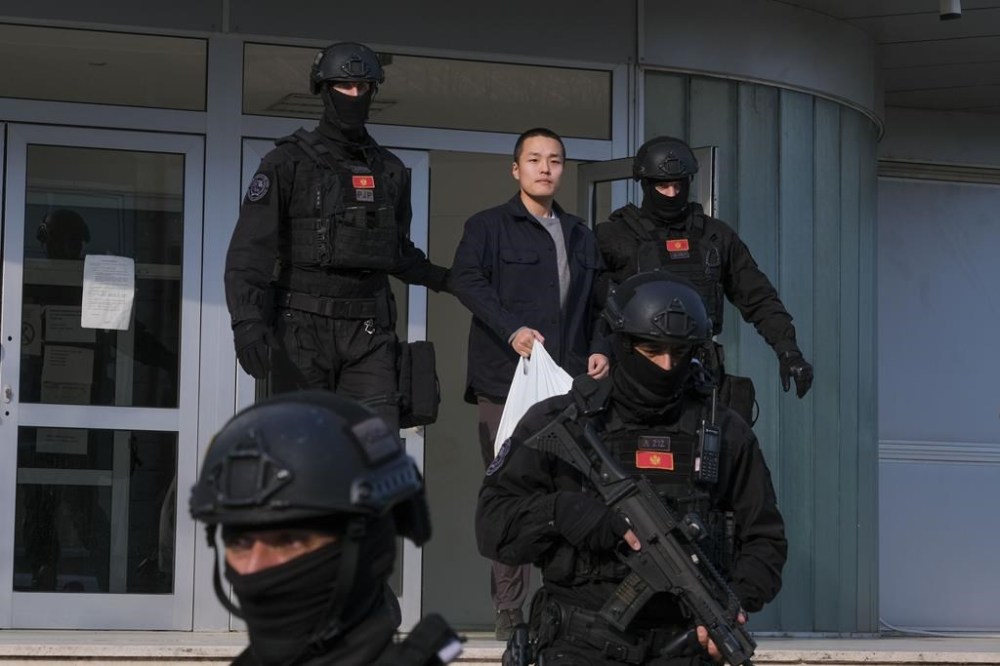 Montenegrin police officers escort South Korean citizen, Terraform Labs founder Do Kwon in Montenegro's capital Podgorica, Saturday, March 23, 2024. Do Kwon was transferred on Saturday from prison, where he had served a 4-month sentence for using a fake passport, to a facility for foreigners pending his announced extradition to his native South Korea. (AP Photo/Risto Bozovic)