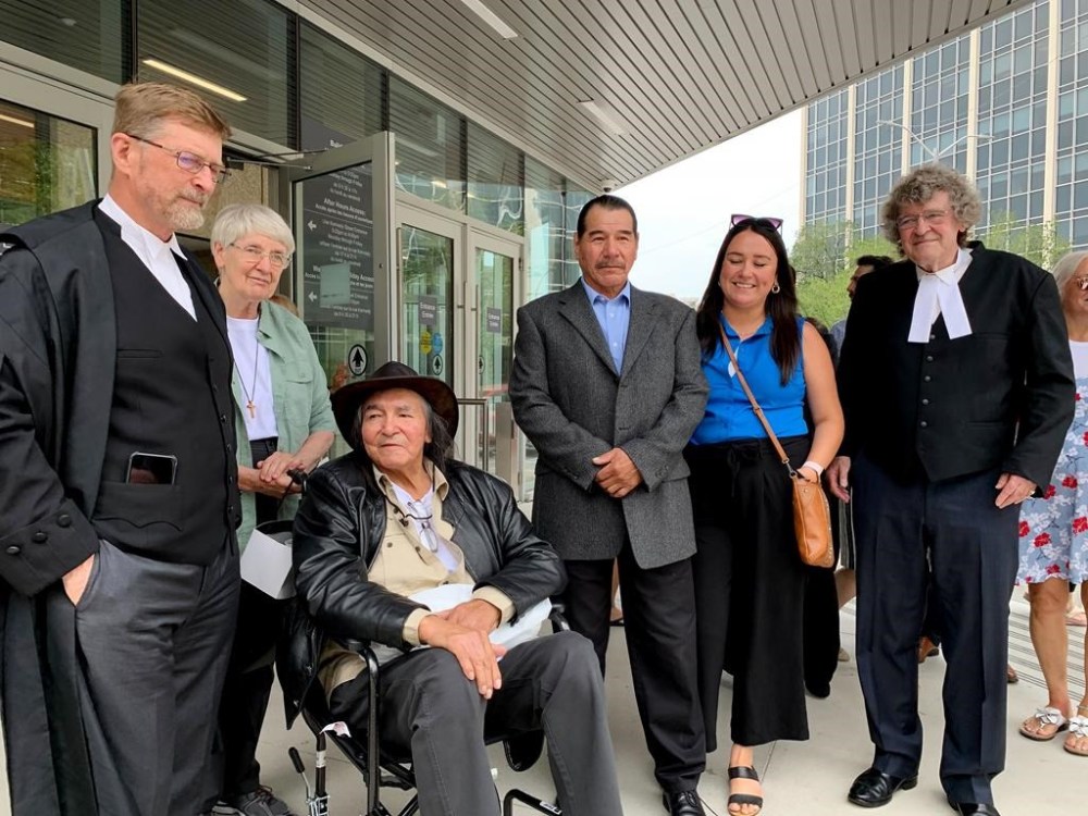 Two First Nations men wrongfully convicted of murdering a restaurant worker in 1973 are suing three levels of government, saying their imprisonment was the result of racial discrimination. Jerome Kennedy, one of the lawyers for the two men and director of Innocence Canada, front left to right, newly acquitted Allan Woodhouse and Brian Anderson, and James Lockyer, another lawyer for the two men and also director of Innocence Canada, speak to the media outside the Winnipeg Law Courts in Winnipeg on Tuesday, July 18, 2023. THE CANADIAN PRESS/Brittany Hobson